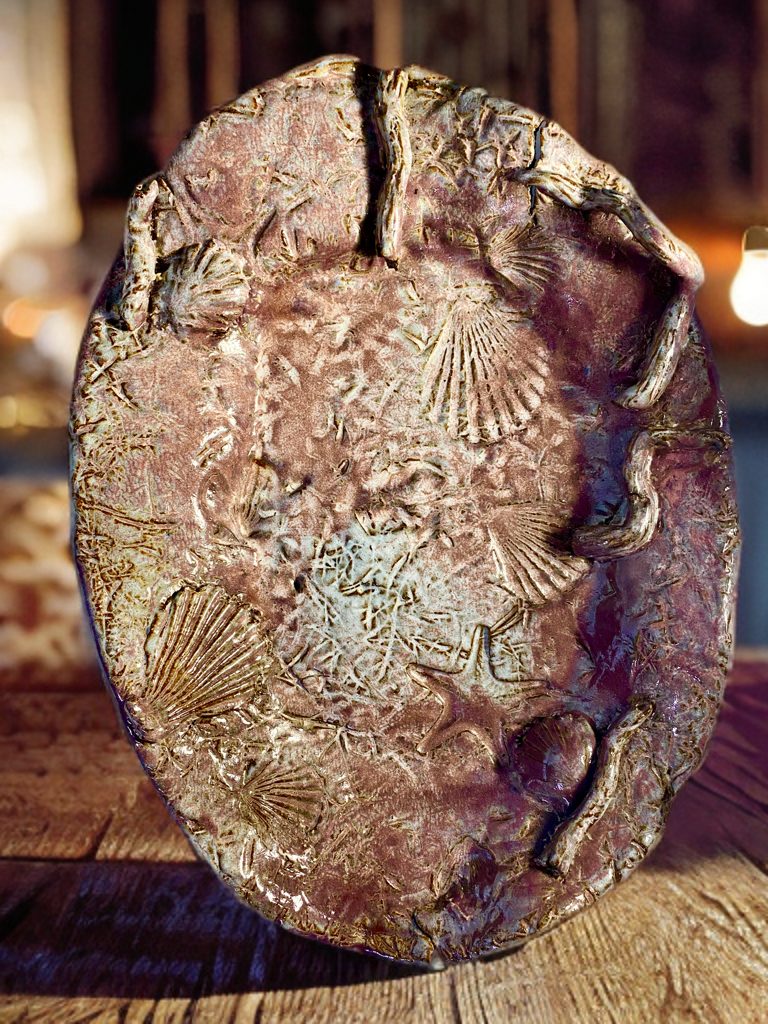 Platter with impressed fossil forms in bronze and copper glaze